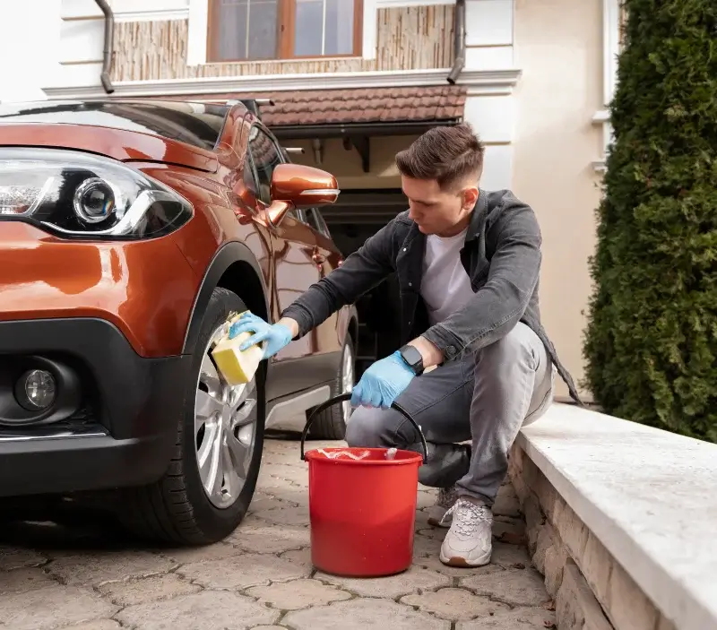Lavage auto à domicile Saint-Malô-du-Bois : professionnel intervenant sur un véhicule